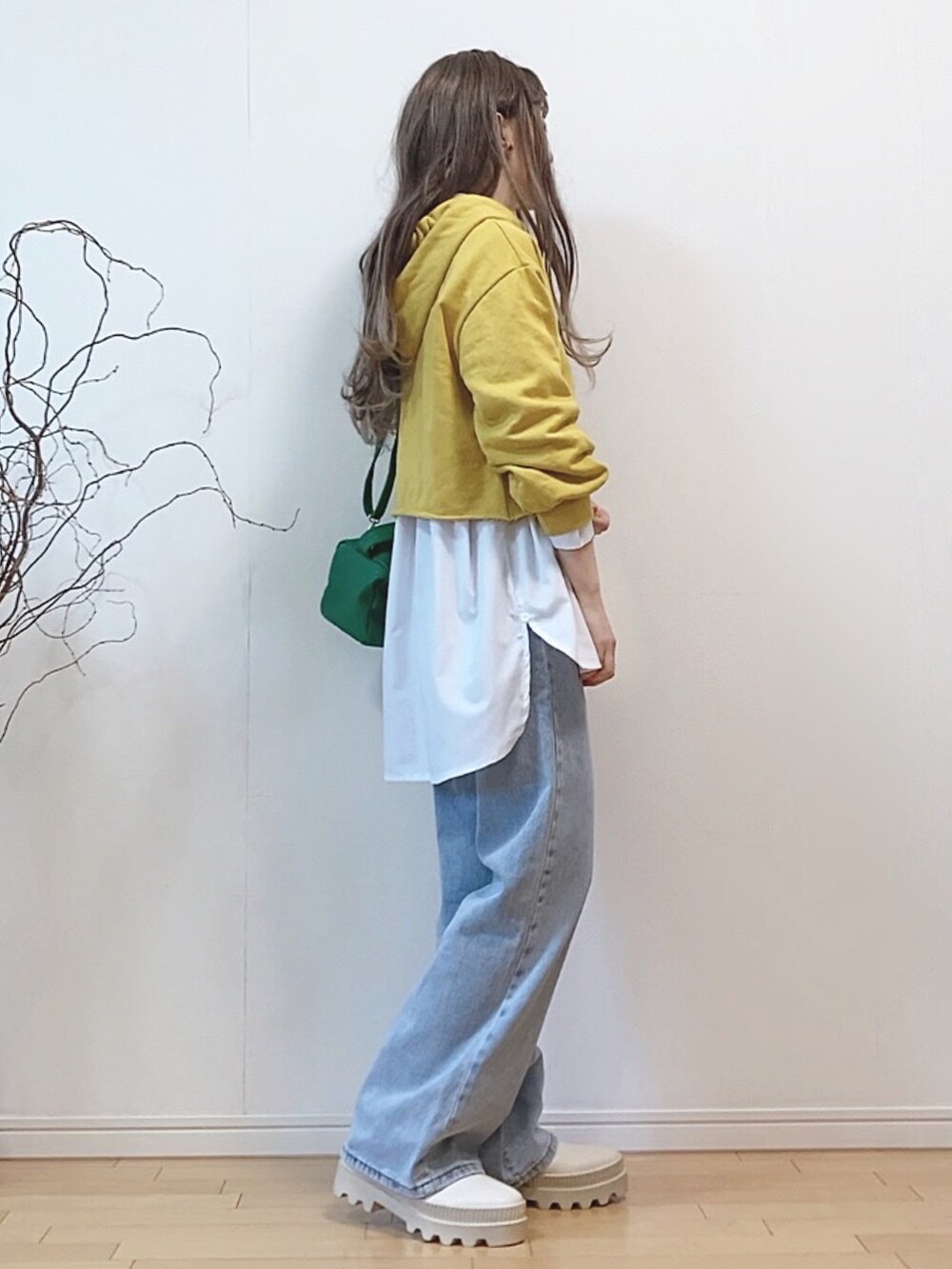 ホワイト系のシャツ/ブラウス、ブルー系のデニムパンツ、グリーン系のショルダーバッグを着用したレディースの冬コーディネートの2枚目の写真