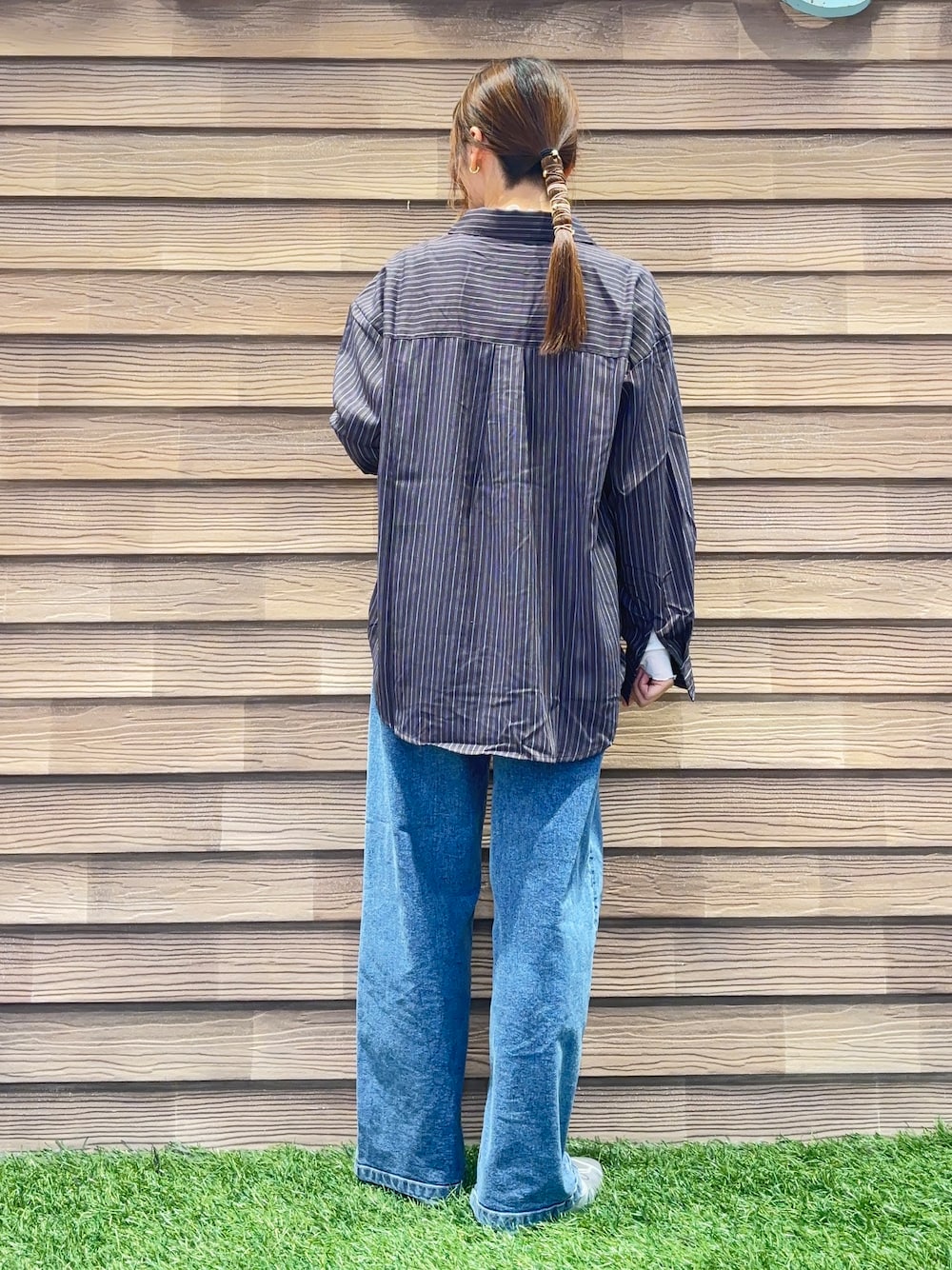 ブラウン系のシャツ/ブラウス、ホワイト系のTシャツ/カットソー、ブルー系のデニムパンツを着用したレディースの秋コーディネートの3枚目の写真