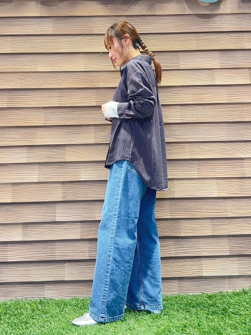 ブラウン系のシャツ/ブラウス、ホワイト系のTシャツ/カットソー、ブルー系のデニムパンツを着用したレディースの秋コーディネートの2枚目の写真