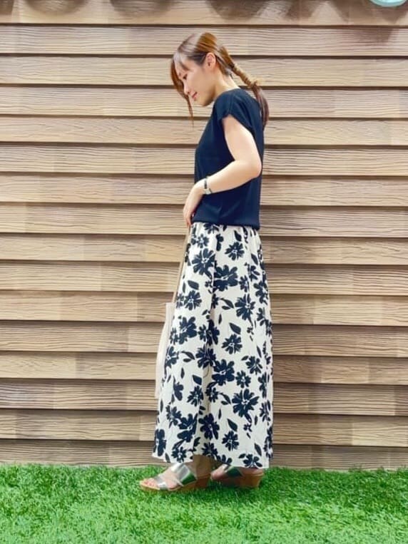 ブラック系のニット/セーター、グリーン系のスカート、シルバー系のサンダルを着用したレディースの夏コーディネートの2枚目の写真