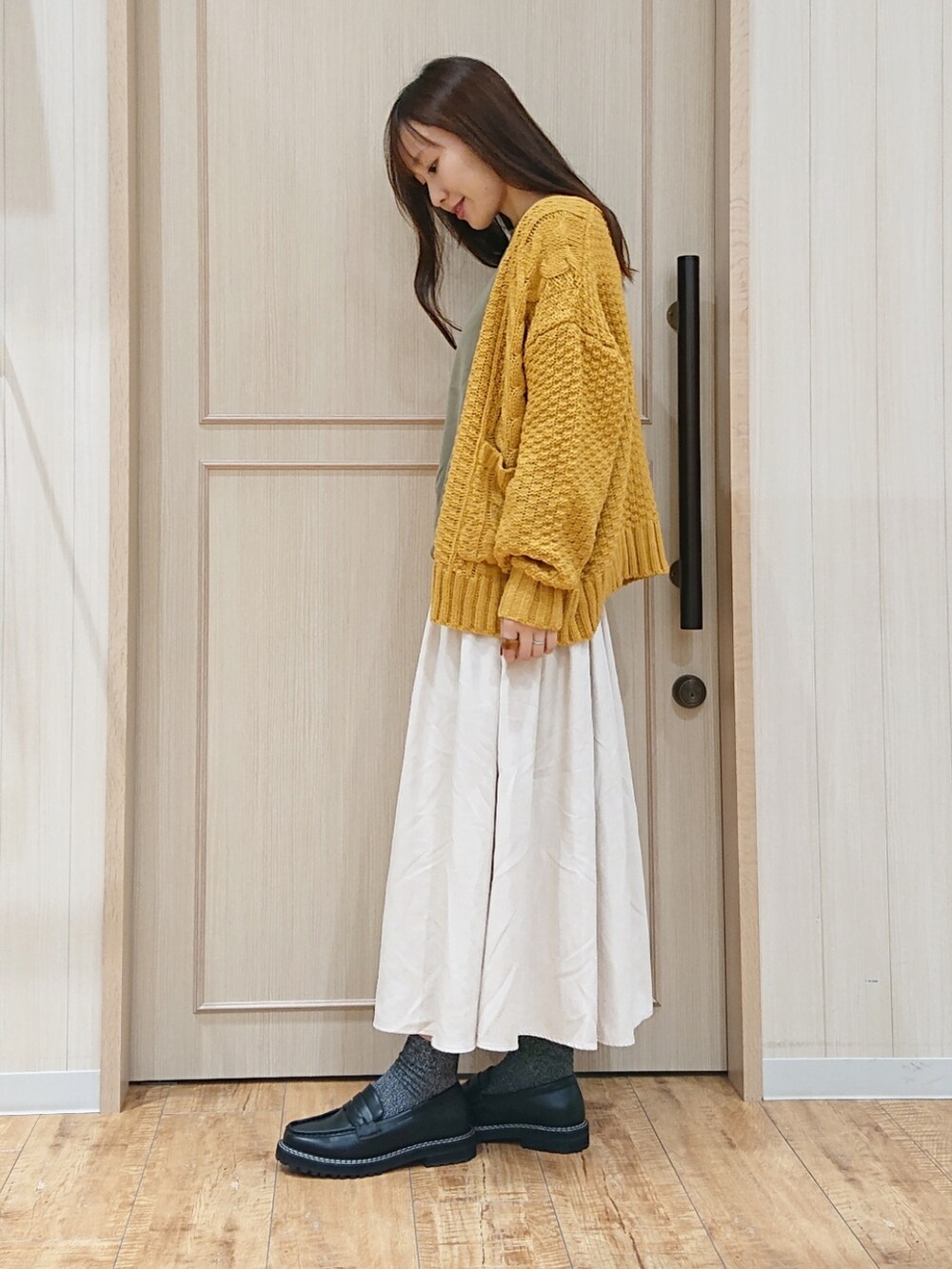 グリーン系のシャツ/ブラウス、イエロー系のカーディガン/ボレロ、ブラック系のドレスシューズを着用したレディースの秋コーディネートの2枚目の写真