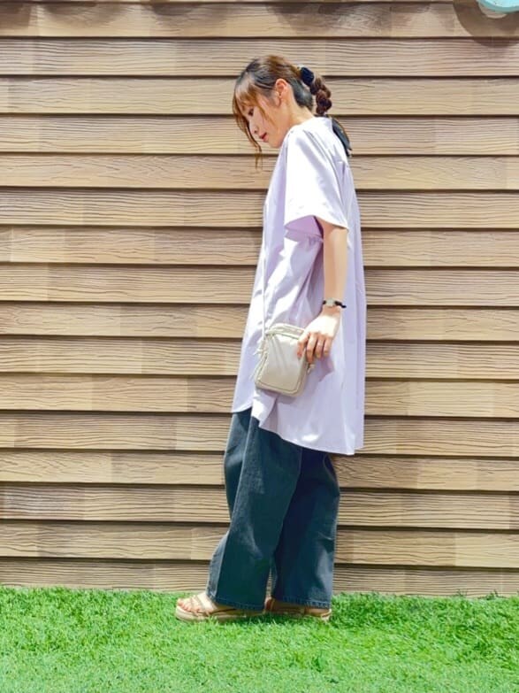 パープル系のチュニック、グレー系のデニムパンツ、ベージュ系のサンダルを着用したレディースの夏コーディネートの2枚目の写真