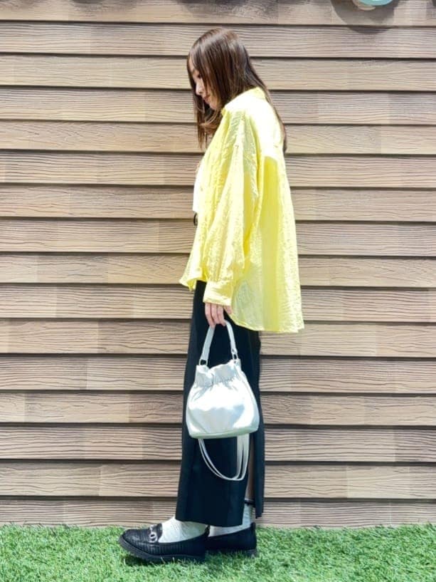 イエロー系のシャツ/ブラウス、ホワイト系のTシャツ/カットソー、ブラック系のスカートを着用したレディースの春コーディネートの2枚目の写真