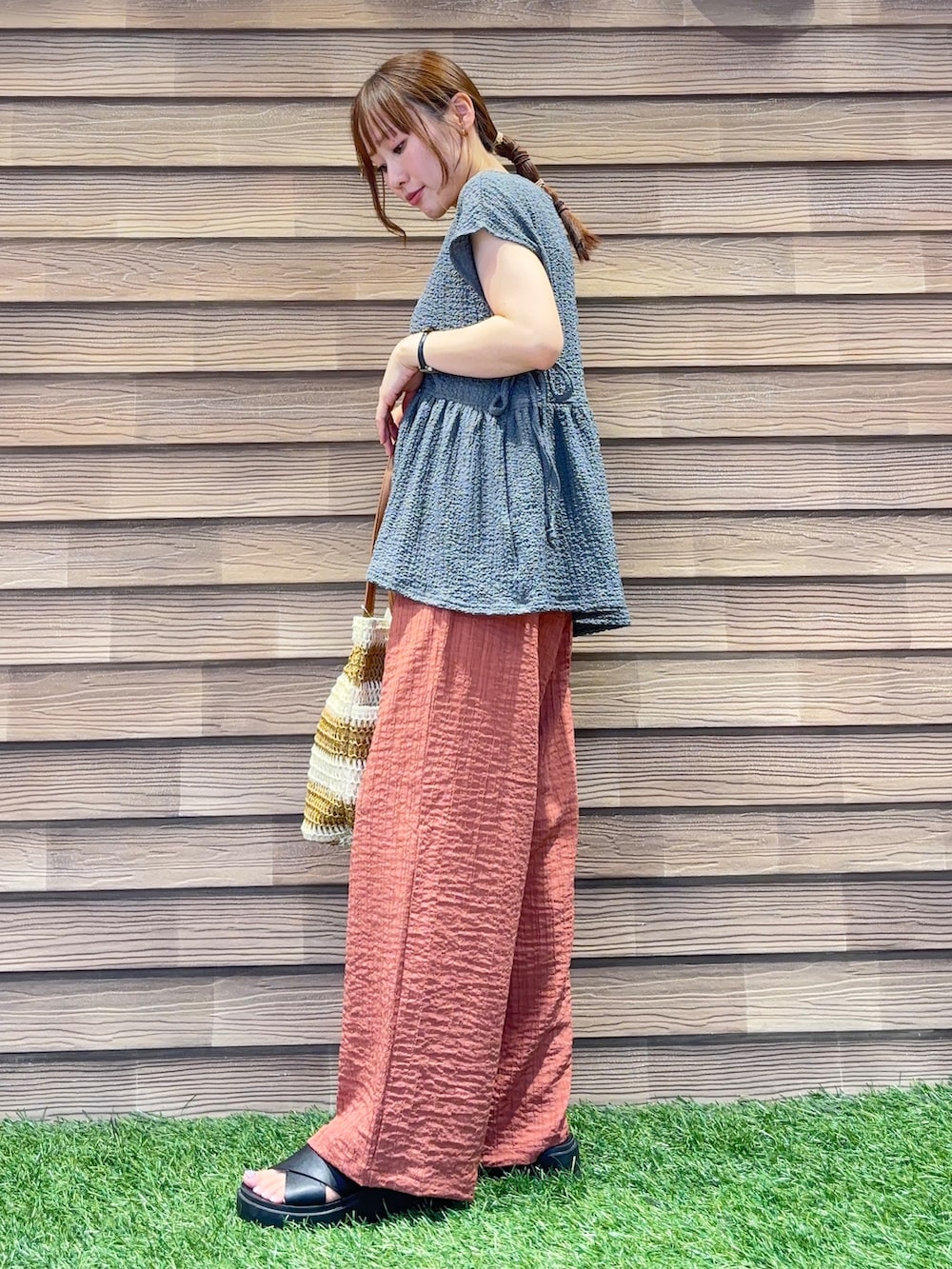 オレンジ系のその他パンツ、ベージュ系のトートバッグを着用したレディースの夏コーディネートの2枚目の写真