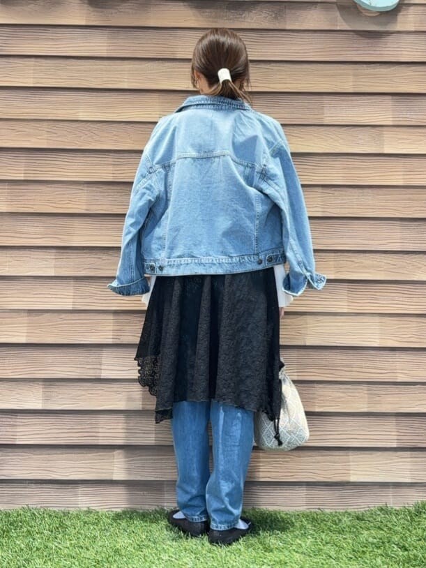 ブルー系のデニムジャケット、ホワイト系のニット/セーター、ブラック系のチュニックを着用したレディースの冬コーディネートの3枚目の写真