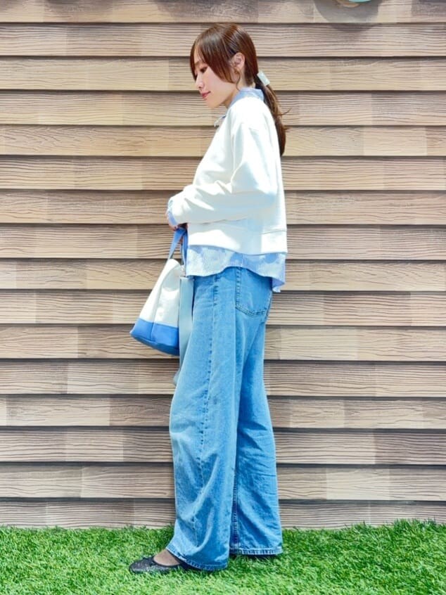 ホワイト系のスウェット、ブルー系のデニムパンツ、ブラック系のその他シューズを着用したレディースの冬コーディネートの2枚目の写真