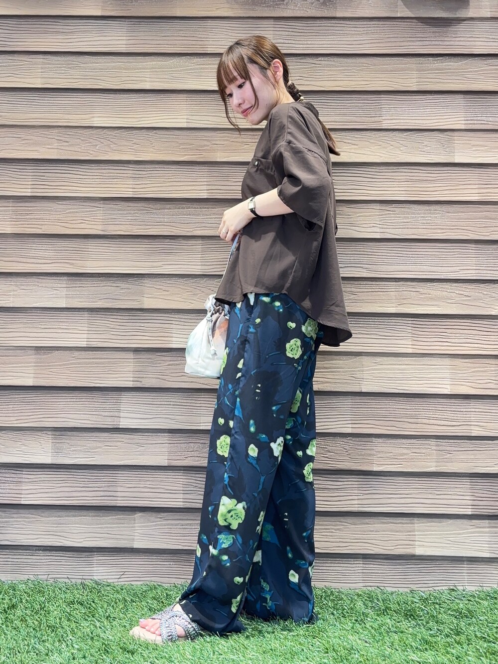 ブルー系のその他パンツ、ブラウン系のサンダル、ベージュ系のショルダーバッグを着用したレディースの夏コーディネートの2枚目の写真