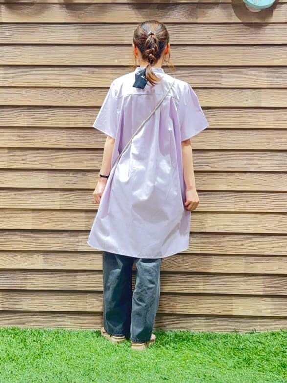 パープル系のチュニック、グレー系のデニムパンツ、ベージュ系のサンダルを着用したレディースの夏コーディネートの3枚目の写真