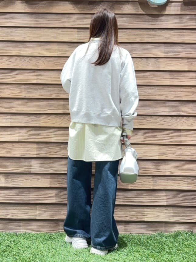 グレー系のスウェット、イエロー系のシャツ/ブラウス、ブルー系のデニムパンツを着用したレディースの春コーディネートの3枚目の写真