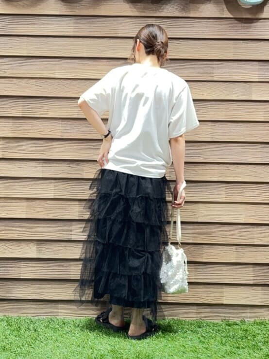 ホワイト系のTシャツ/カットソー、ブラック系のスカート、ホワイト系のショルダーバッグを着用したレディースの夏コーディネートの3枚目の写真