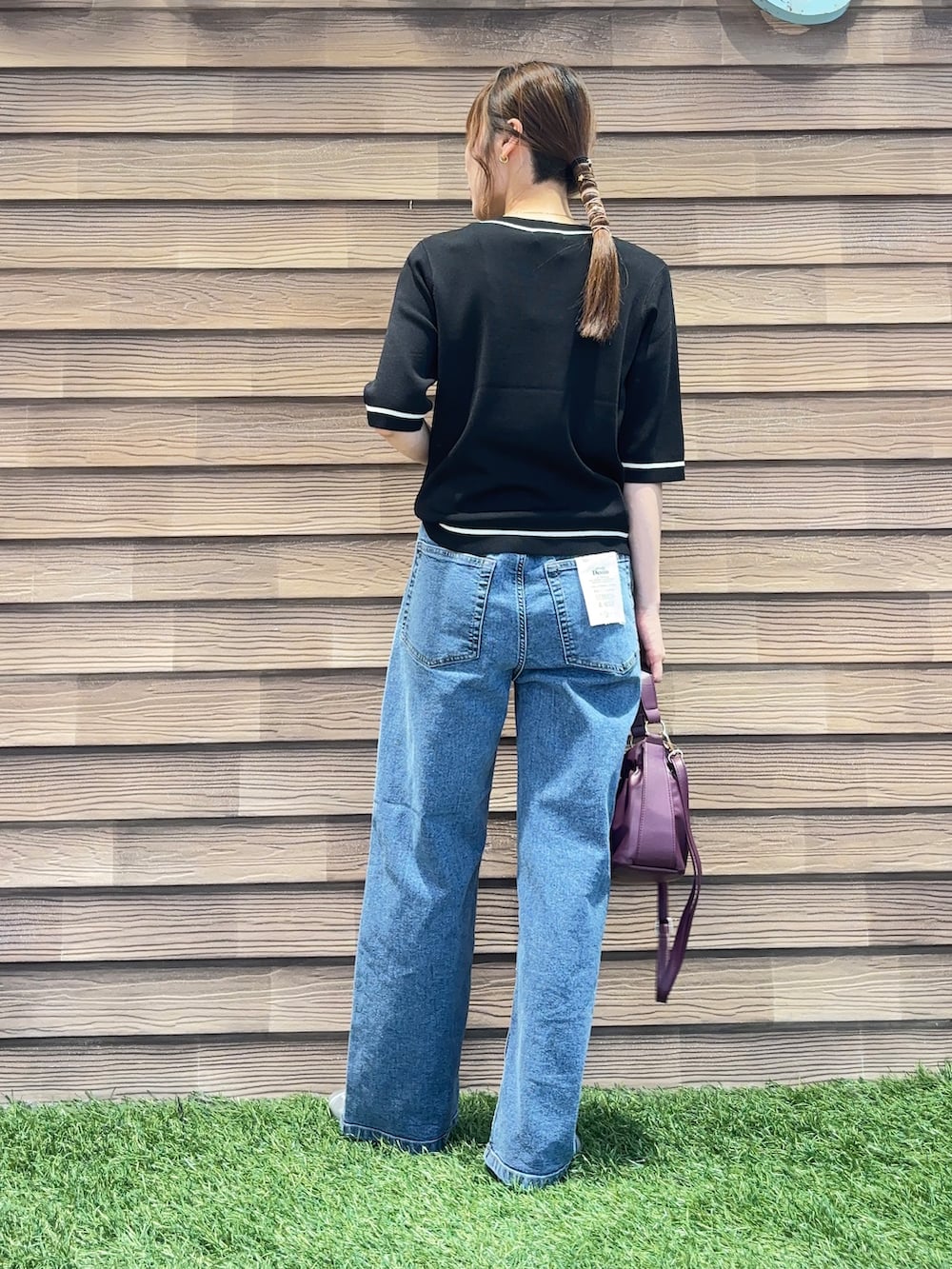 ブラック系のカーディガン/ボレロ、ブルー系のデニムパンツ、レッド系のショルダーバッグを着用したレディースの秋コーディネートの3枚目の写真