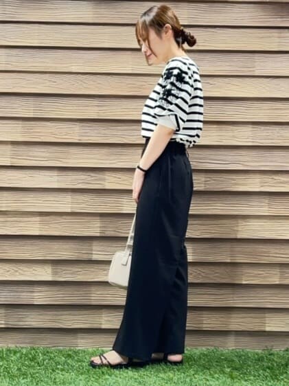 ホワイト系のニット/セーター、ブラック系のその他パンツ、ベージュ系のショルダーバッグを着用したレディースの春コーディネートの2枚目の写真