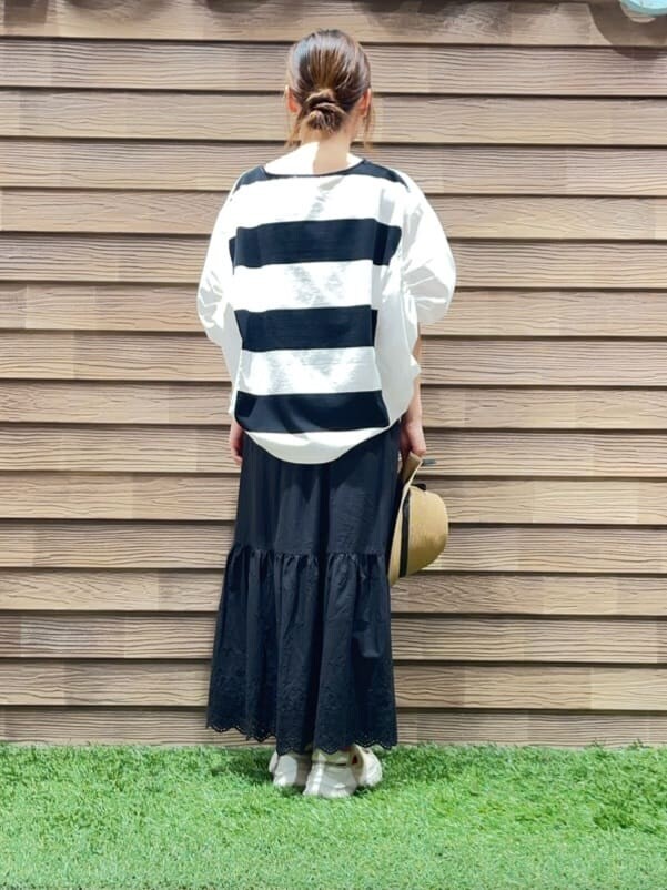 ブラック系のTシャツ/カットソー、ブラック系のスカート、イエロー系のハットを着用したレディースの春コーディネートの3枚目の写真