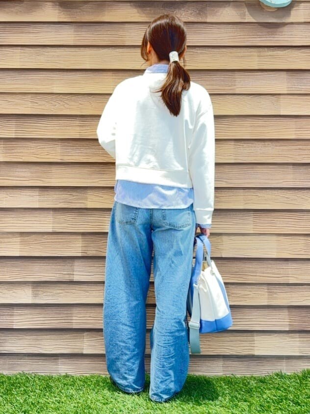 ホワイト系のスウェット、ブルー系のデニムパンツ、ブラック系のその他シューズを着用したレディースの冬コーディネートの3枚目の写真