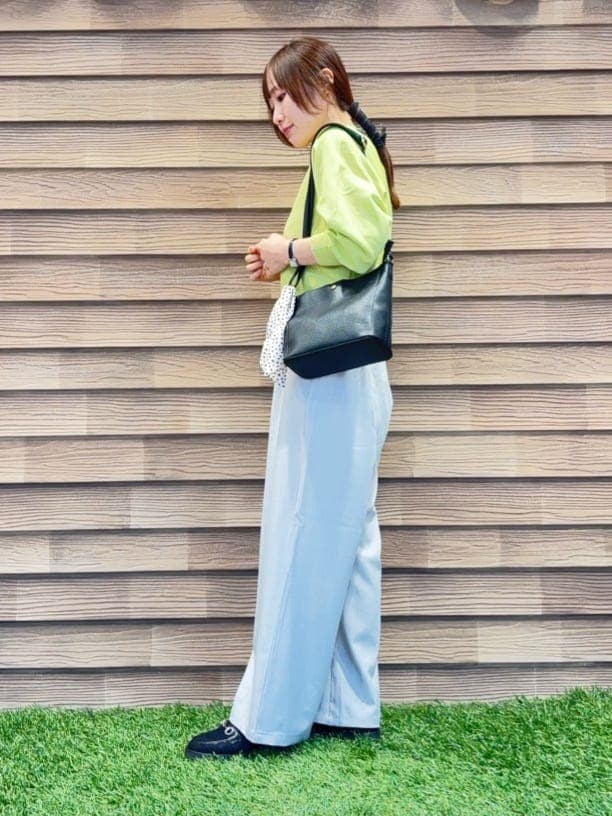 グリーン系のニット/セーター、グレー系のその他パンツ、ブラック系のパンプスを着用したレディースの春コーディネートの2枚目の写真