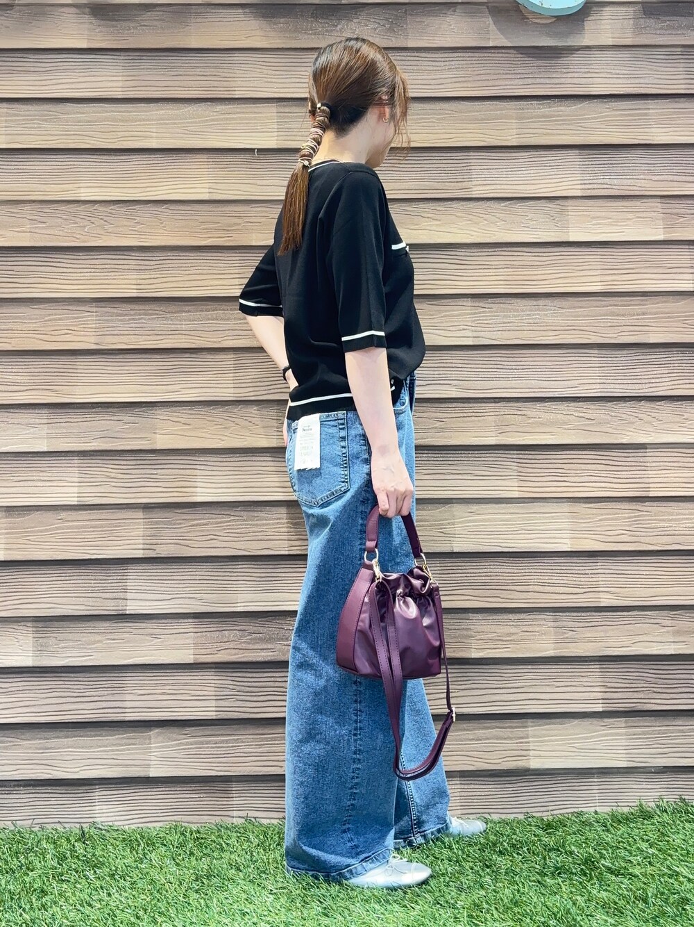 ブラック系のカーディガン/ボレロ、ブルー系のデニムパンツ、レッド系のショルダーバッグを着用したレディースの秋コーディネートの4枚目の写真
