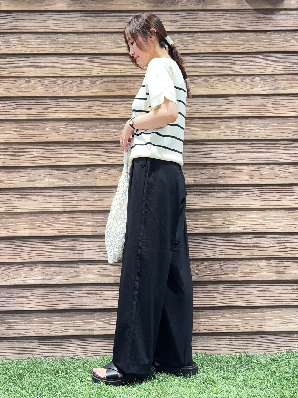 ホワイト系のトートバッグ、ブラック系のその他パンツ、ブラック系のサンダルを着用したレディースの春コーディネートの2枚目の写真