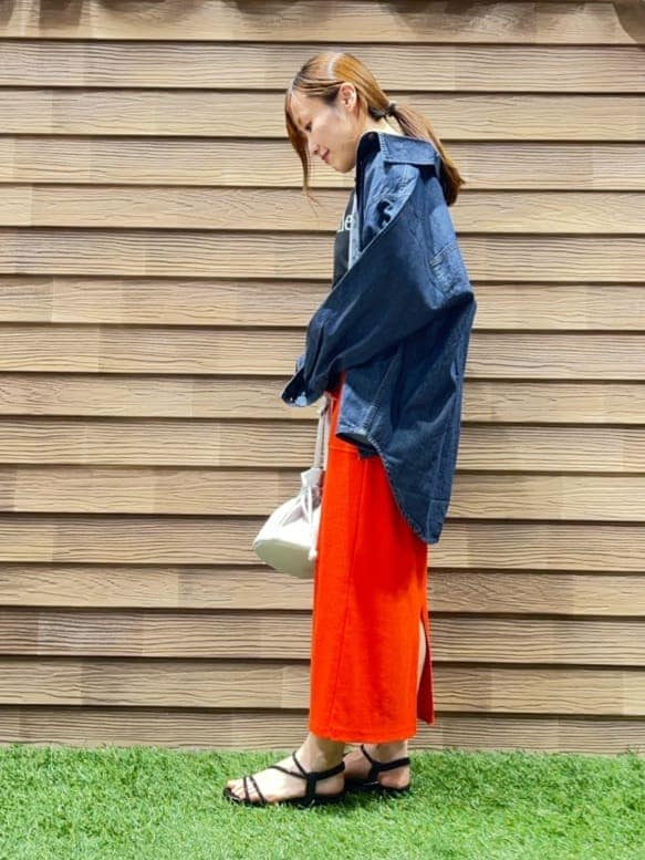 ブルー系のシャツ/ブラウス、ブラック系のTシャツ/カットソー、オレンジ系のスカートを着用したレディースの春コーディネートの2枚目の写真