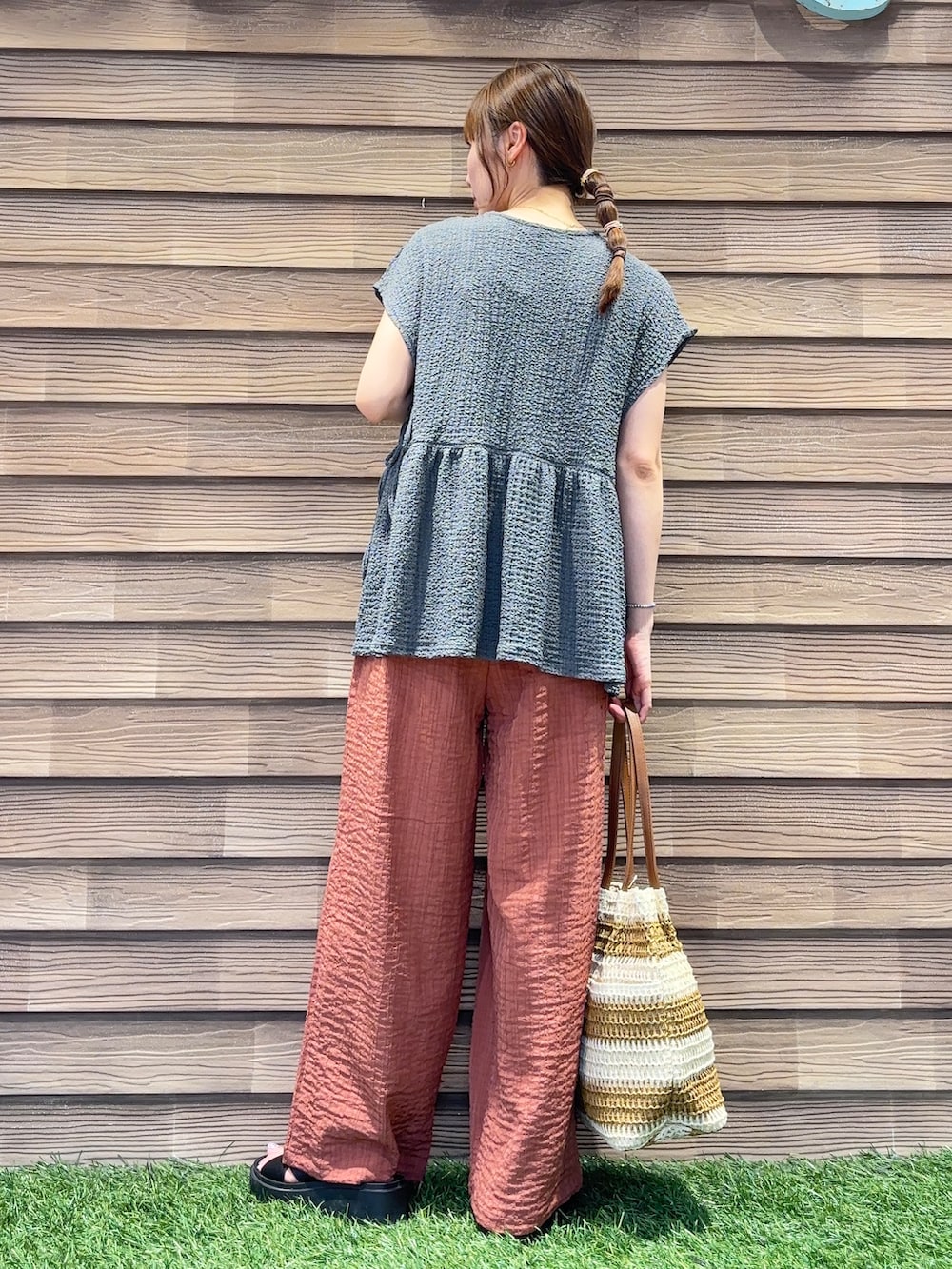 オレンジ系のその他パンツ、ベージュ系のトートバッグを着用したレディースの夏コーディネートの3枚目の写真