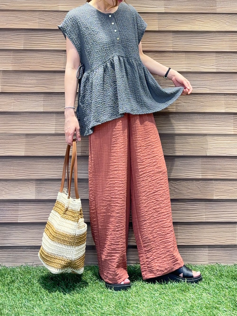 オレンジ系のその他パンツ、ベージュ系のトートバッグを着用したレディースの夏コーディネートの4枚目の写真