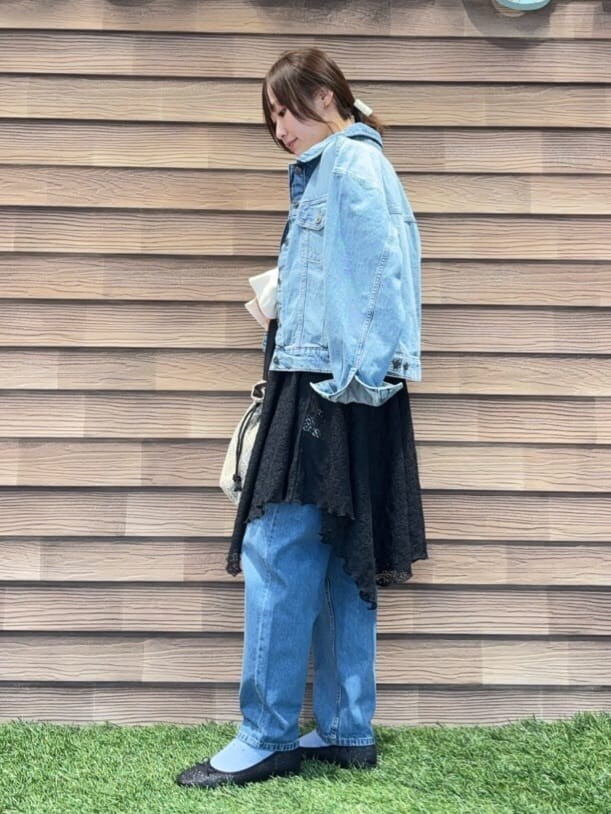 ブルー系のデニムジャケット、ホワイト系のニット/セーター、ブラック系のチュニックを着用したレディースの冬コーディネートの2枚目の写真