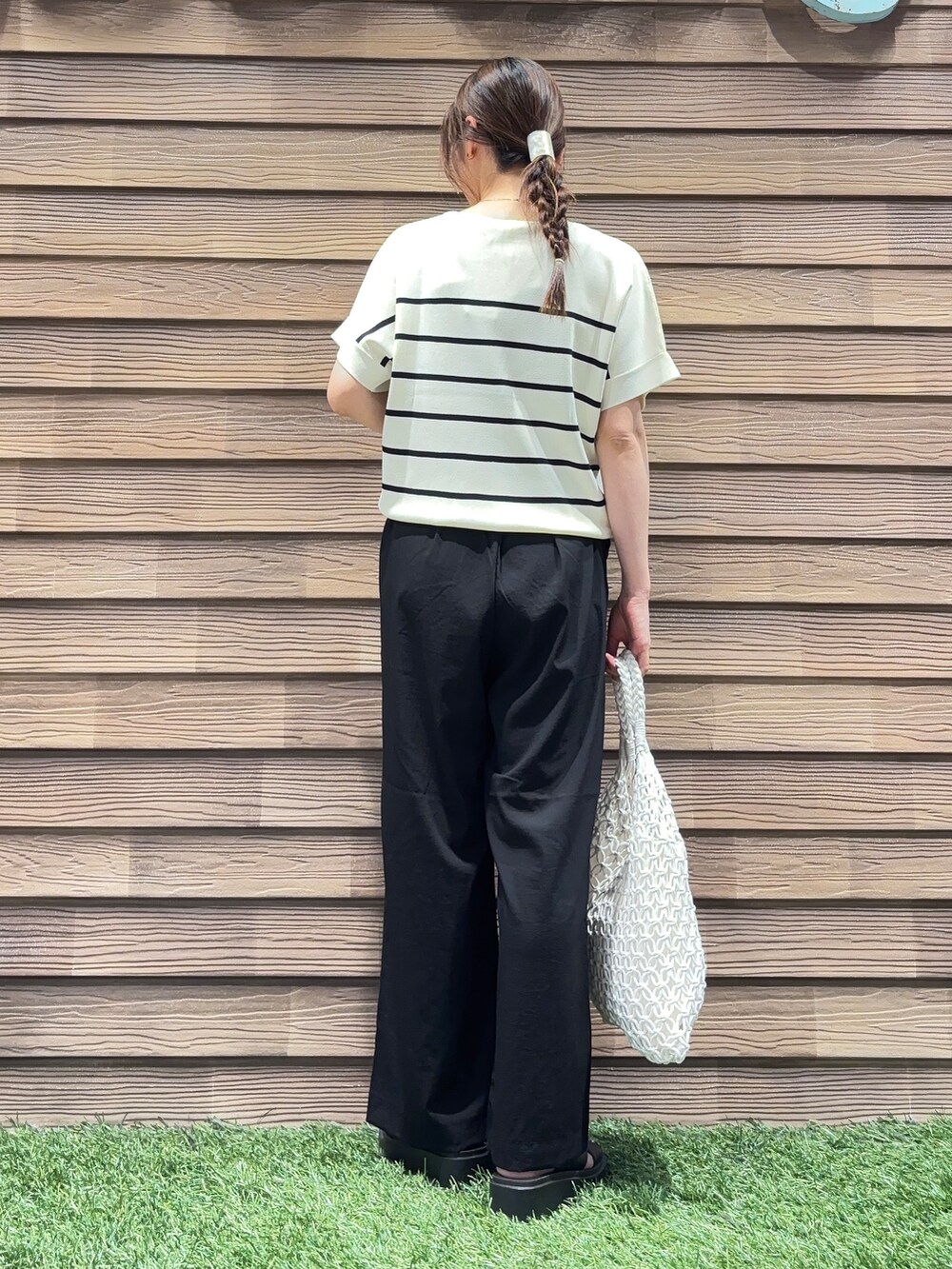 ホワイト系のトートバッグ、ブラック系のその他パンツ、ブラック系のサンダルを着用したレディースの春コーディネートの3枚目の写真