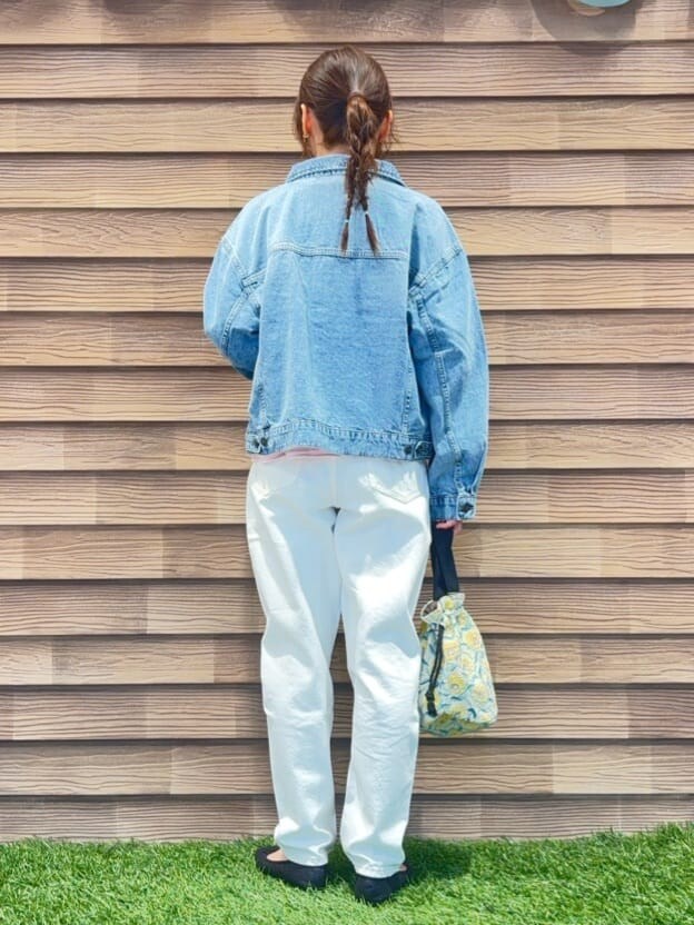 ブルー系のデニムジャケット、ピンク系のスウェット、ホワイト系のデニムパンツを着用したレディースの冬コーディネートの3枚目の写真