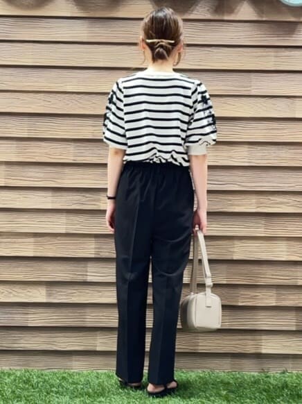 ホワイト系のニット/セーター、ブラック系のその他パンツ、ベージュ系のショルダーバッグを着用したレディースの春コーディネートの3枚目の写真