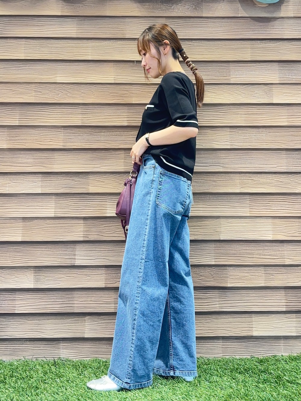 ブラック系のカーディガン/ボレロ、ブルー系のデニムパンツ、レッド系のショルダーバッグを着用したレディースの秋コーディネートの2枚目の写真