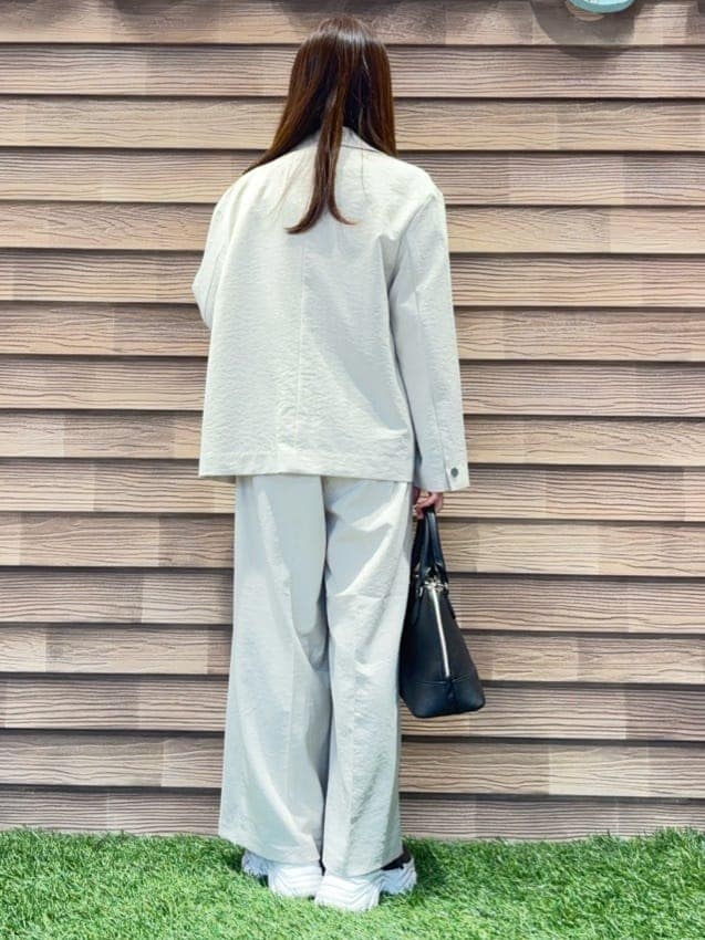 ベージュ系のテーラードジャケット、ホワイト系のTシャツ/カットソー、ベージュ系のその他パンツを着用したレディースの春コーディネートの3枚目の写真