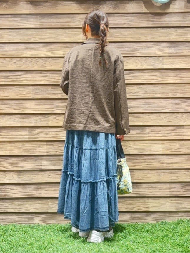 ブラウン系のテーラードジャケット、ホワイト系のTシャツ/カットソー、ブルー系のデニムスカートを着用したレディースの冬コーディネートの3枚目の写真