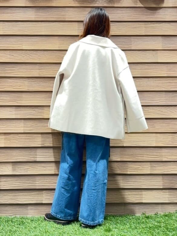 ホワイト系のテーラードジャケット、グレー系のニット/セーター、ブルー系のデニムパンツを着用したレディースの秋コーディネートの4枚目の写真