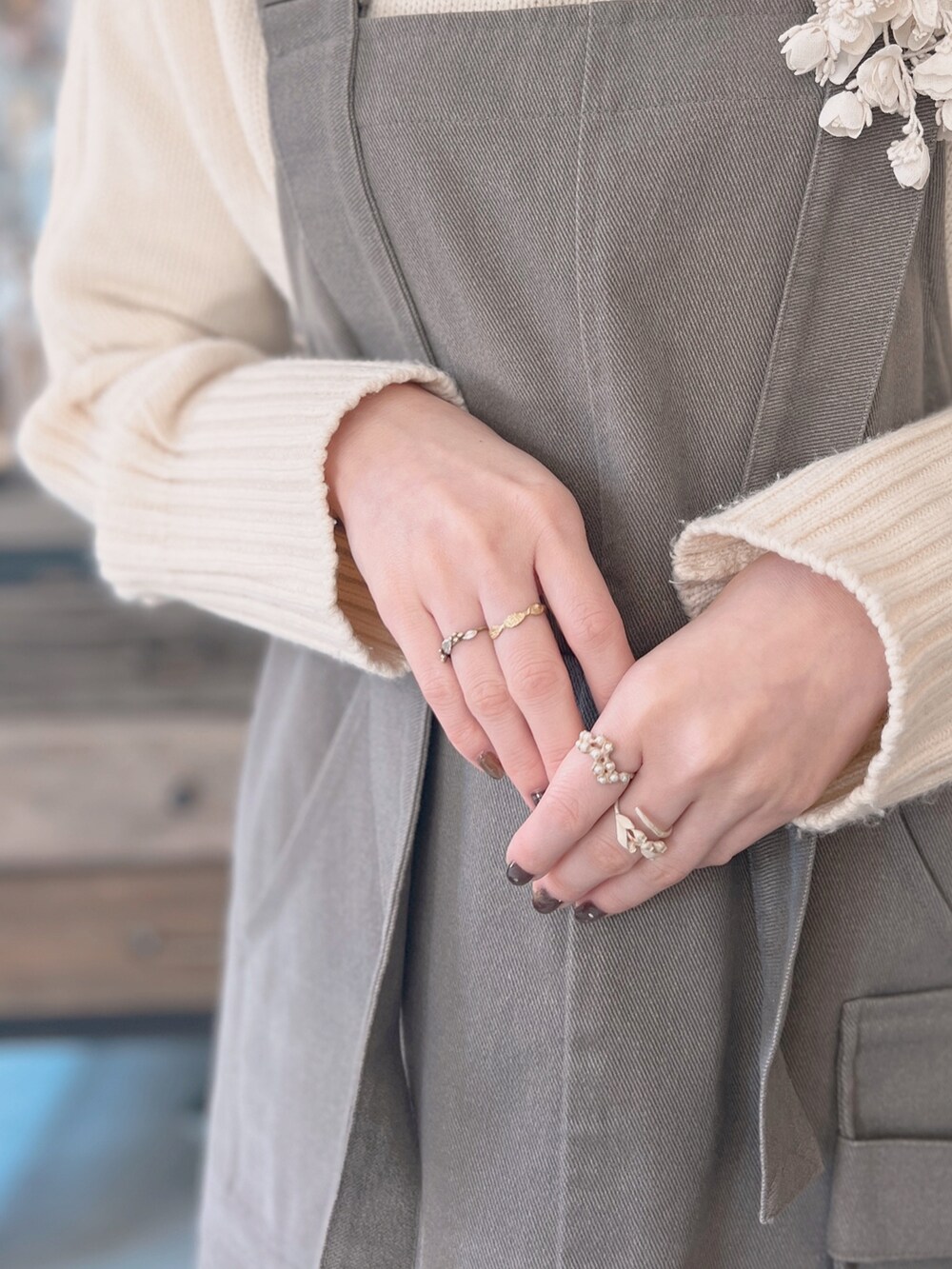 ホワイト系のトートバッグ、グレー系のジャンパースカート、ホワイト系のニット/セーターを着用したレディースの冬コーディネートの4枚目の写真