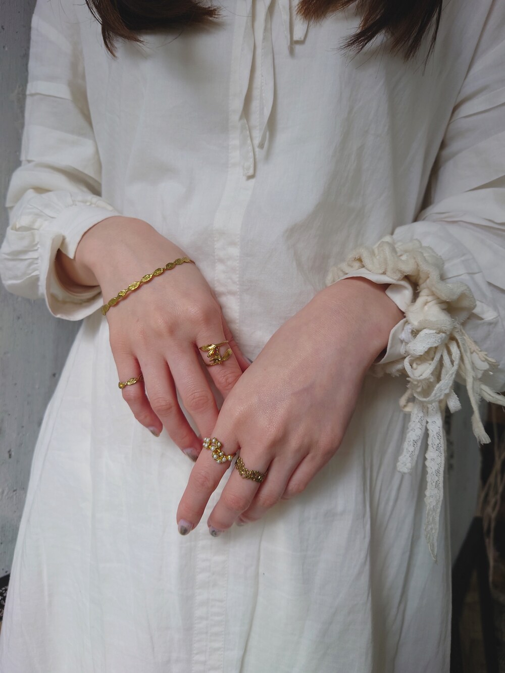 ホワイト系のワンピース、ブラック系のレインシューズ、その他のショルダーバッグを着用したレディースの春コーディネートの2枚目の写真