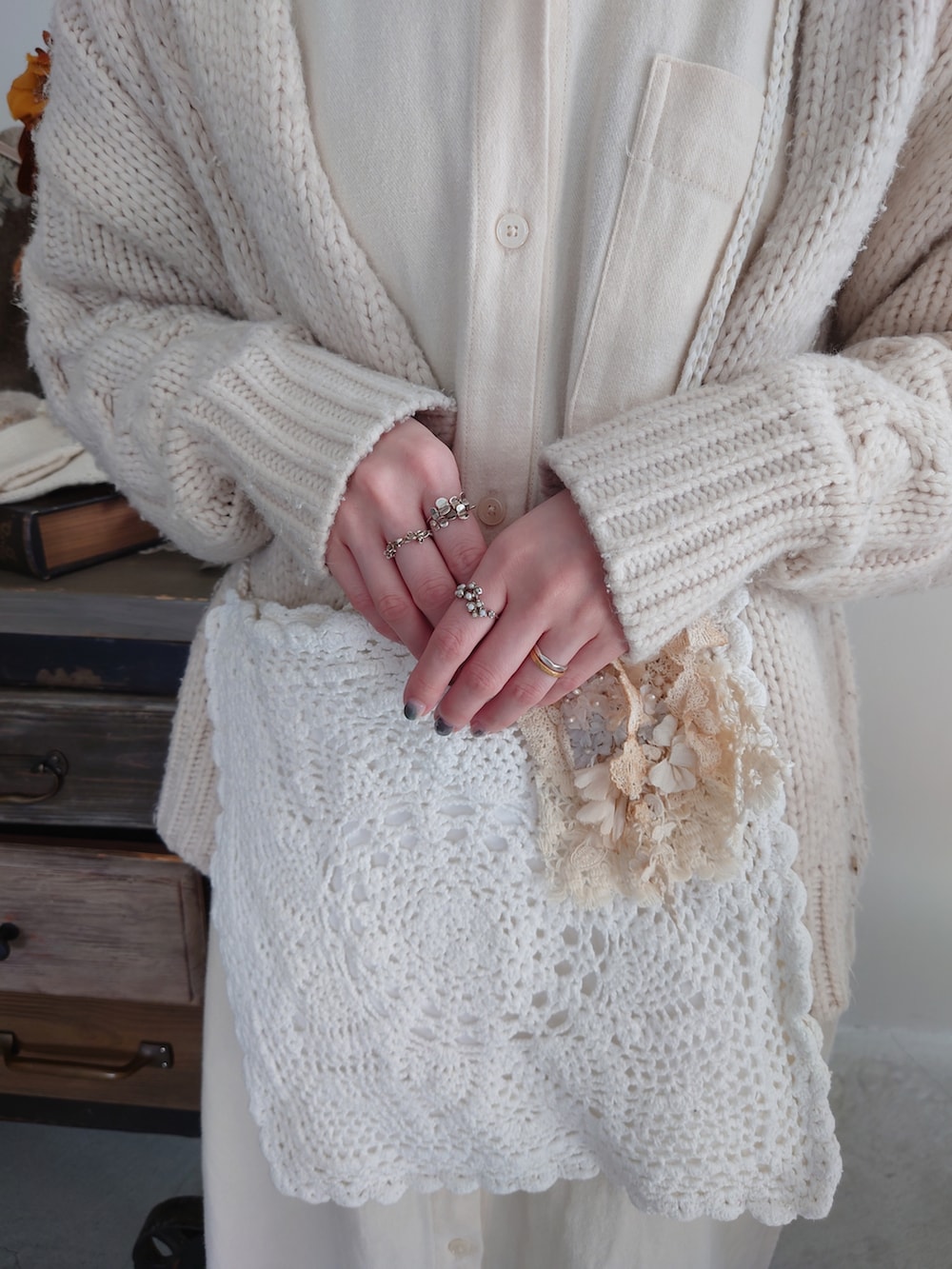 ホワイト系のショルダーバッグ、ホワイト系のカーディガン/ボレロ、ホワイト系のワンピースを着用したレディースの春コーディネートの3枚目の写真