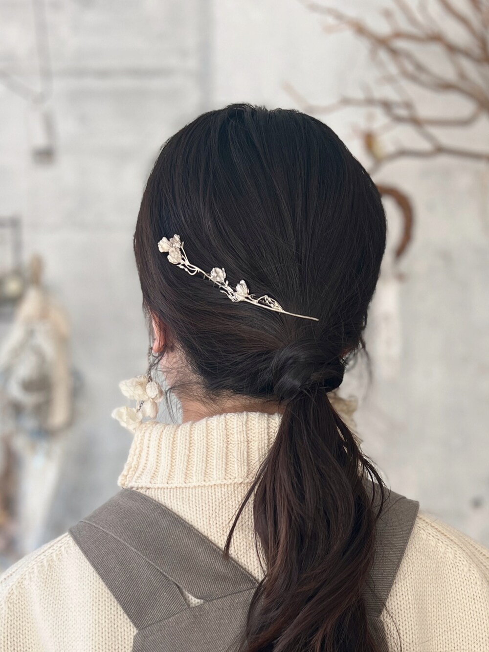 ホワイト系のトートバッグ、グレー系のジャンパースカート、ホワイト系のニット/セーターを着用したレディースの冬コーディネートの3枚目の写真