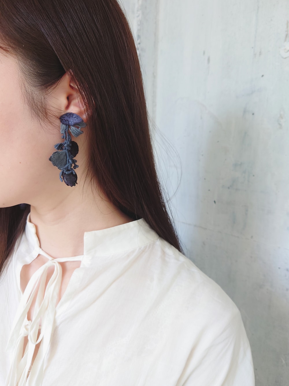 ホワイト系のワンピース、ブラック系のレインシューズ、その他のショルダーバッグを着用したレディースの春コーディネートの3枚目の写真