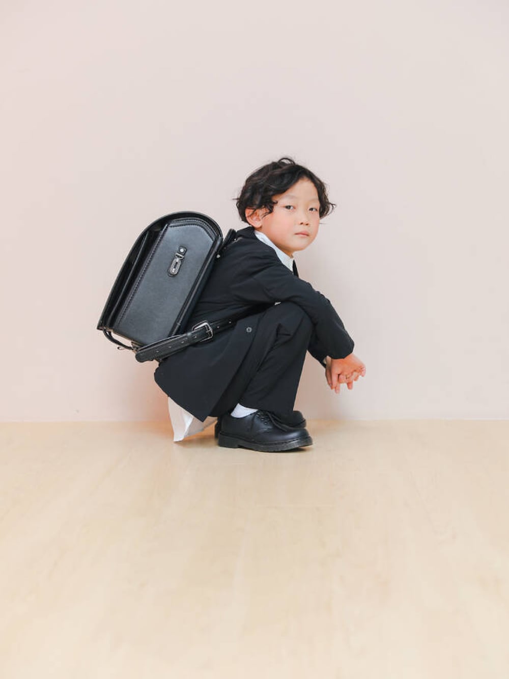 ブラック系のローファー、ブラック系のその他アウター、ホワイト系のシャツ/ブラウスを着用したキッズの春コーディネートの2枚目の写真