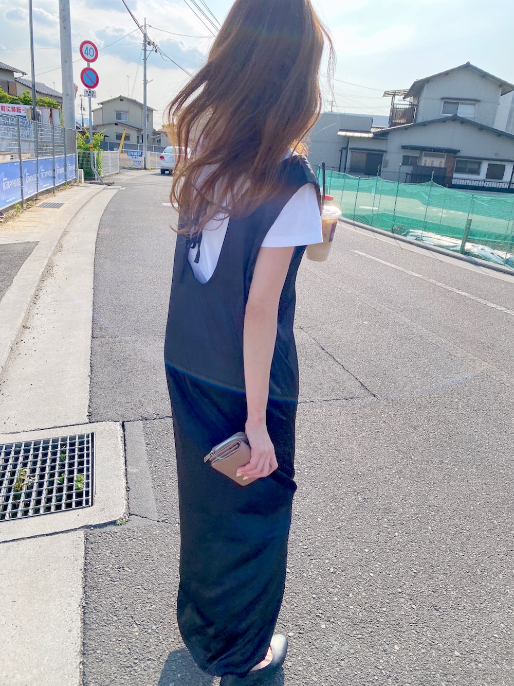 ブラック系のワンピース、ブラック系のパンプス、ホワイト系のTシャツ/カットソーを着用したレディースの夏コーディネートの3枚目の写真