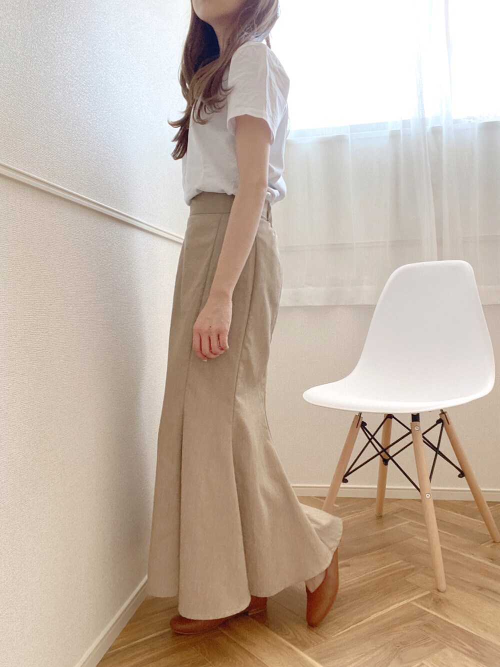 ベージュ系のスカート、ブラック系のパンプス、ホワイト系のTシャツ/カットソーを着用したレディースの夏コーディネートの2枚目の写真