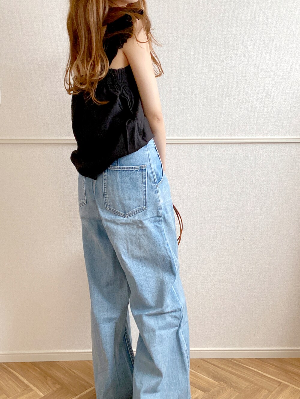 ブラック系のタンクトップ、ブラック系のバレエシューズ、ブルー系のデニムパンツを着用したレディースの夏コーディネートの2枚目の写真