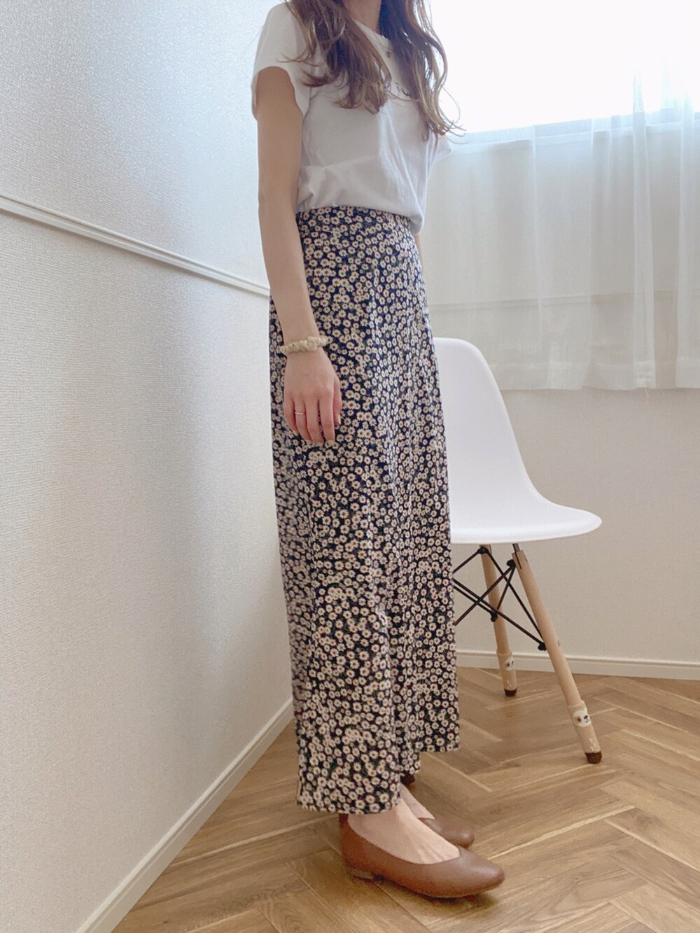 ブルー系のスカート、ホワイト系のTシャツ/カットソー、ブラック系のパンプスを着用したレディースの春コーディネートの2枚目の写真