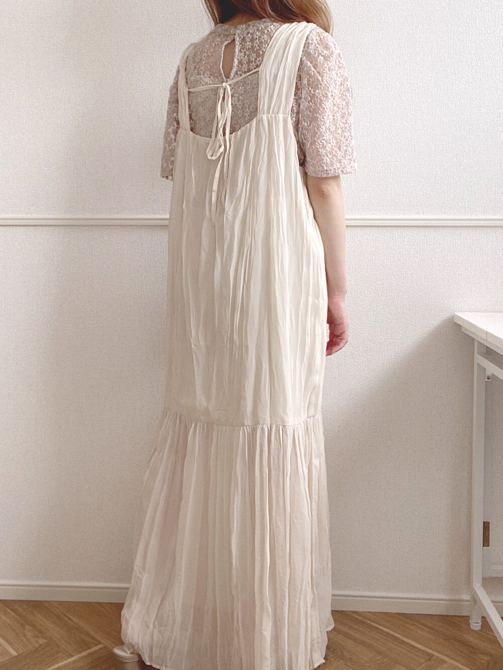 ホワイト系のワンピース、ベージュ系のTシャツ/カットソーを着用したレディースの夏コーディネートの2枚目の写真