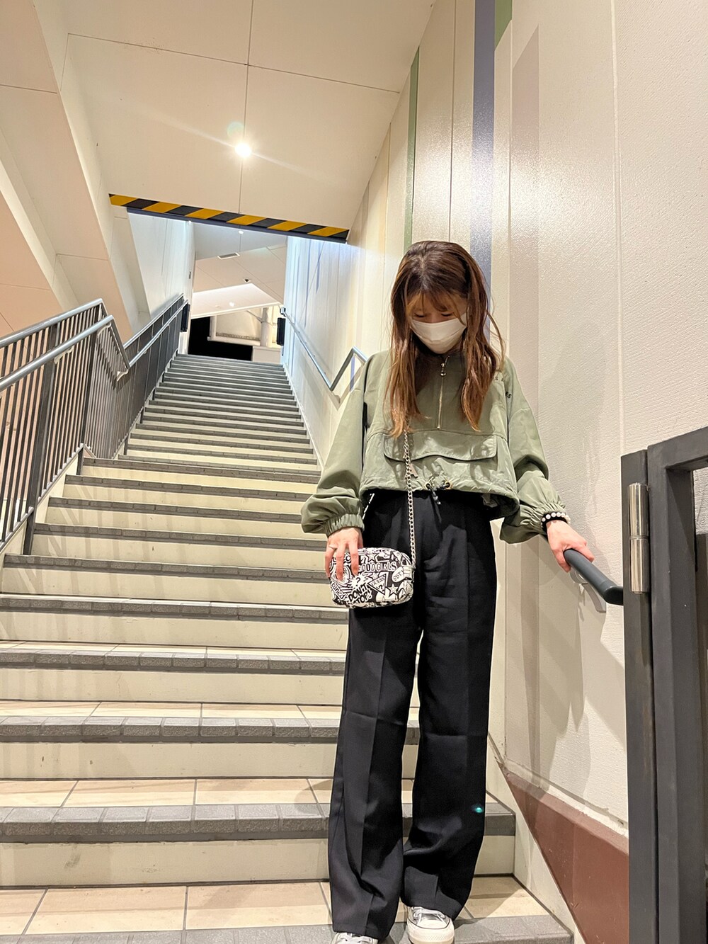 ブラック系のパンツ、グリーン系のパーカー、その他のショルダーバッグを着用したレディースの春コーディネートの2枚目の写真