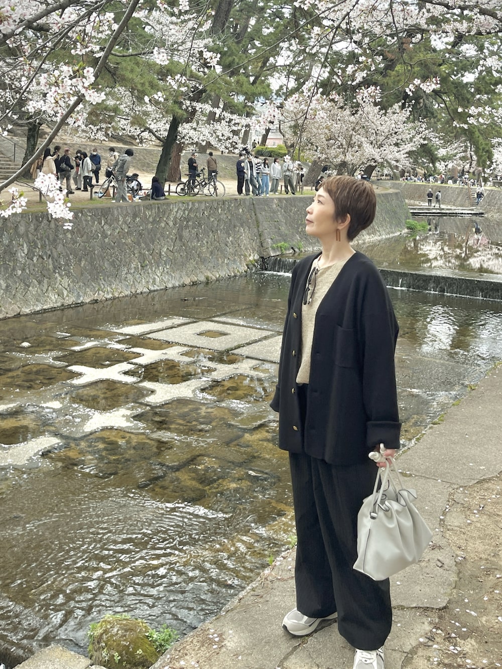 ブラック系のニット/セーター、ベージュ系のニット/セーター、その他のその他パンツを着用したレディースの春コーディネートの3枚目の写真