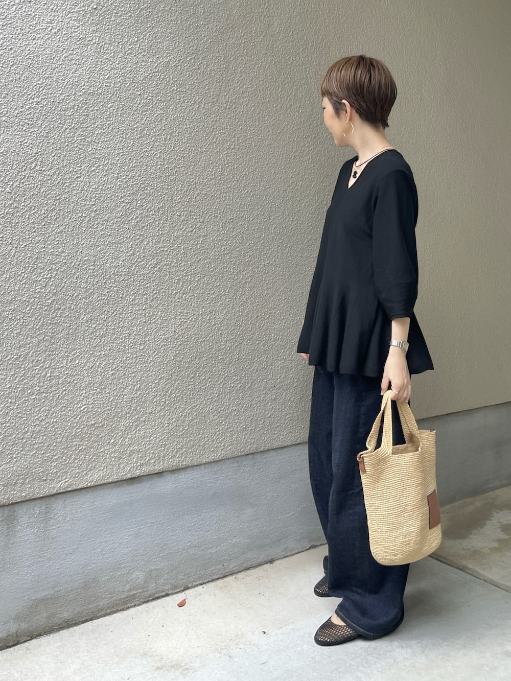 ブラック系のバレエシューズ、ブルー系のデニムパンツ、ブラック系のニット/セーターを着用したレディースの夏コーディネートの3枚目の写真