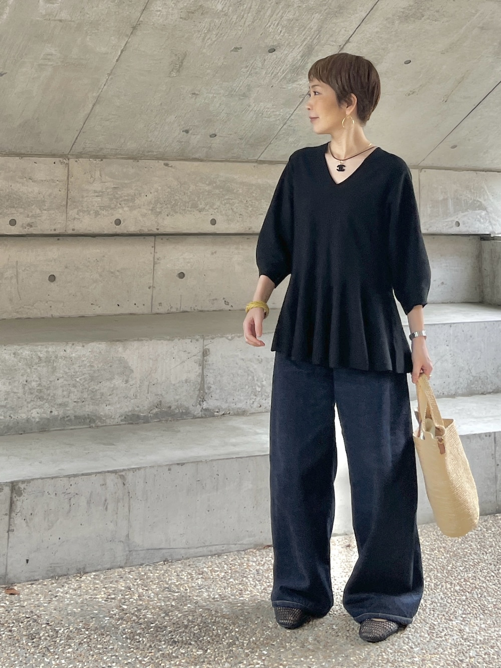 ブラック系のバレエシューズ、ブルー系のデニムパンツ、ブラック系のニット/セーターを着用したレディースの夏コーディネートの5枚目の写真