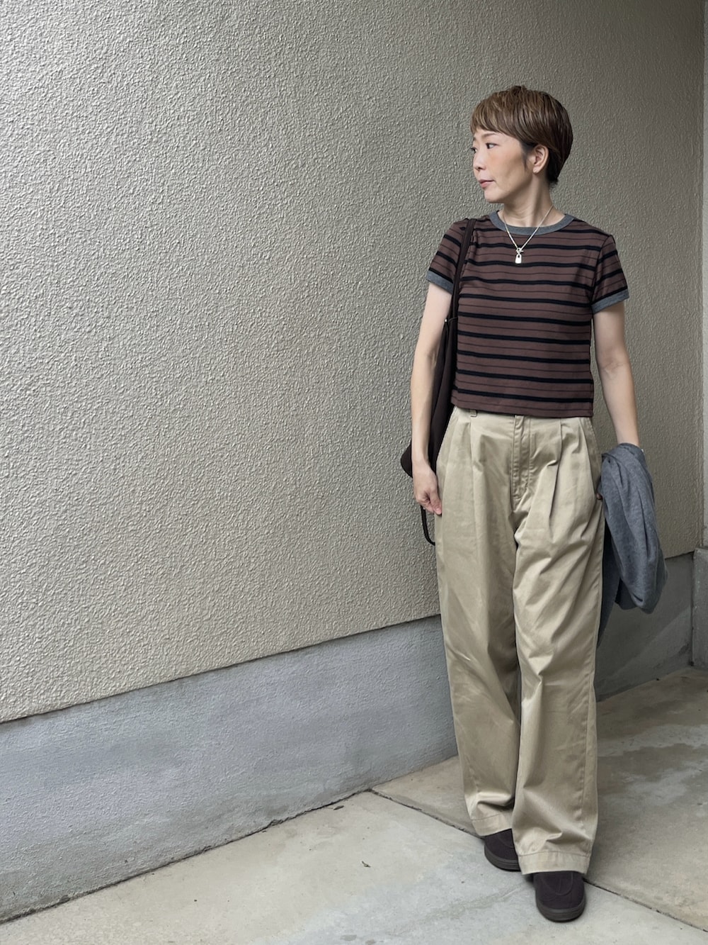 ブラウン系のTシャツ/カットソー、ベージュ系のチノパンツ、ブラウン系のローファーを着用したレディースの秋コーディネートの3枚目の写真