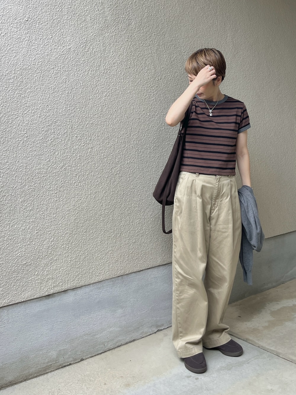 ブラウン系のTシャツ/カットソー、ベージュ系のチノパンツ、ブラウン系のローファーを着用したレディースの秋コーディネートの2枚目の写真