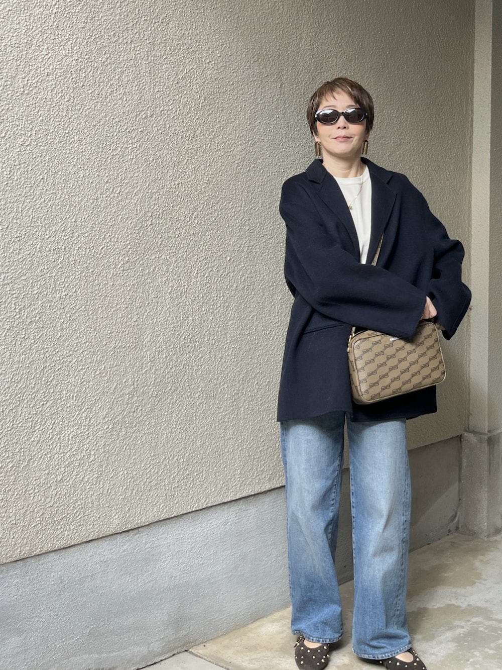 ブルー系のジャケット/アウター、ホワイト系のニット/セーター、ブルー系のデニムパンツを着用したレディースの春コーディネートの3枚目の写真